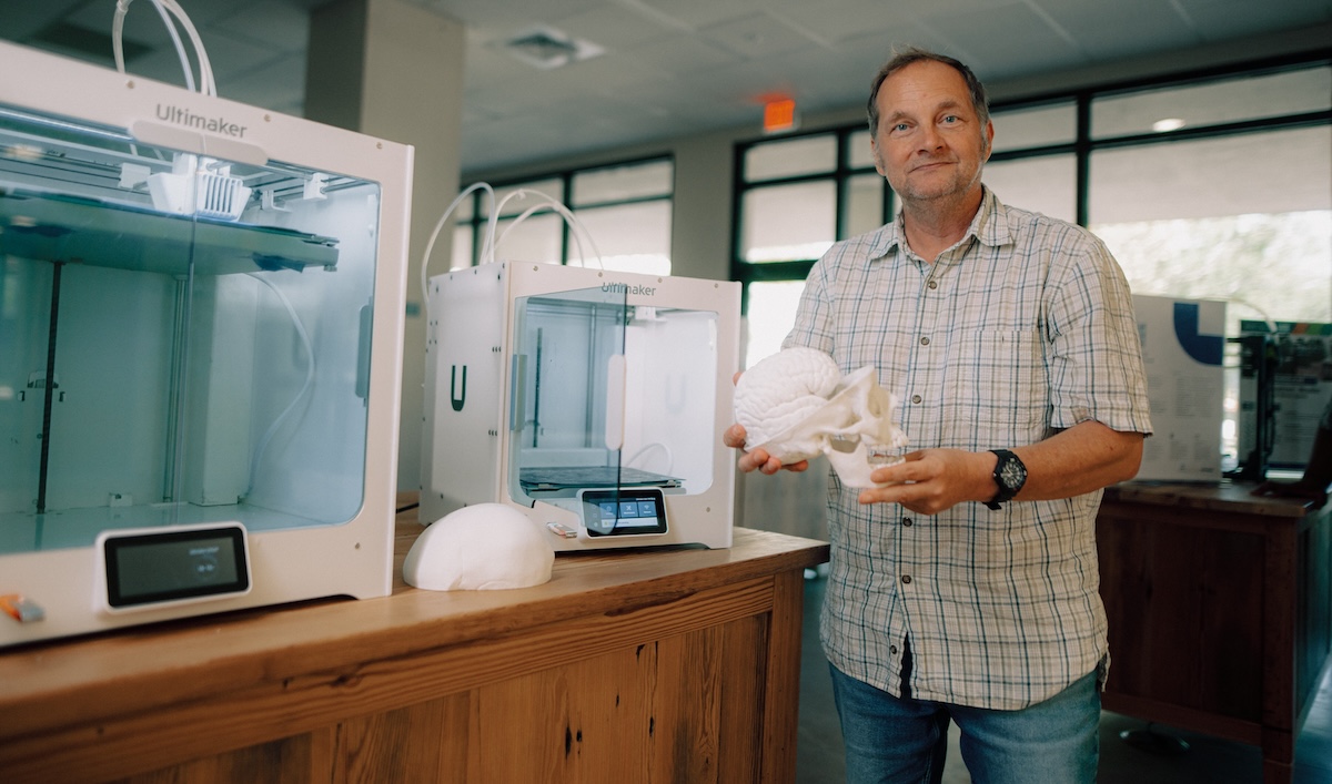 man holding 3d printed skull and brain