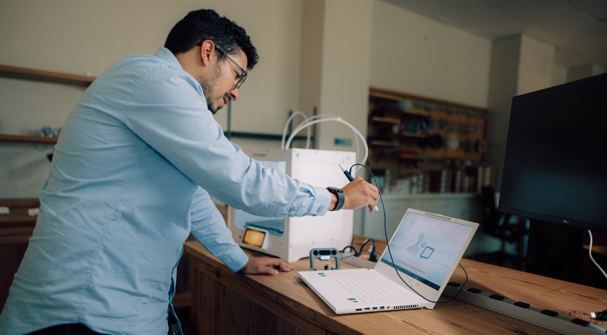 a person using the zSpace laptop with pen controller